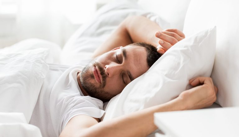 man sleeping in bed at home