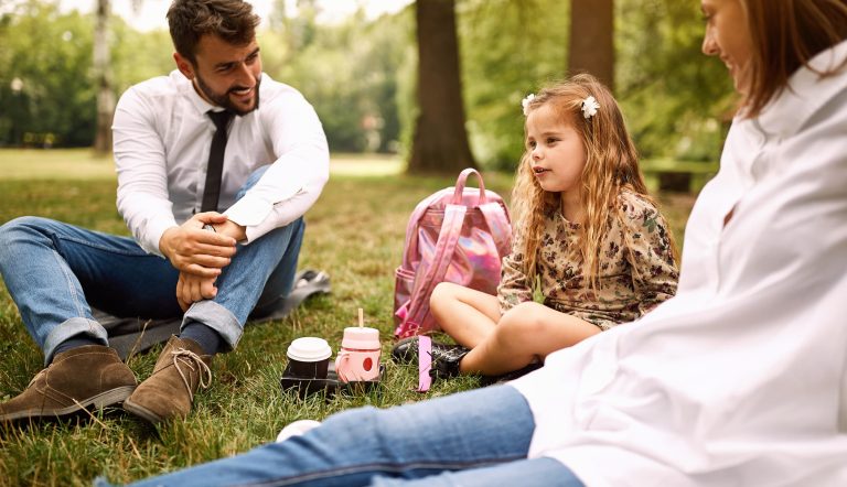 daughter with their parent sitting and resting at park.